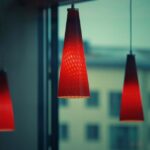 Een moderne woonkamer met verschillende stijlen hanglampen die de ruimte verlichten en karakter geven aan het interieur.